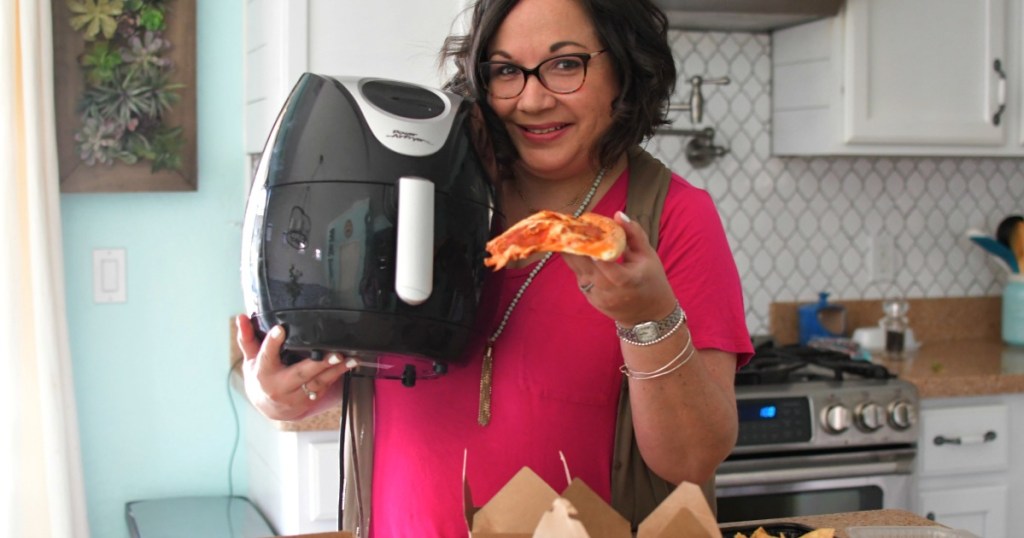 woman reheating pizza in air fryer