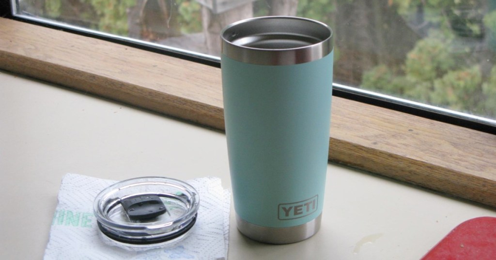 seafoam green YETI tumbler next to lid