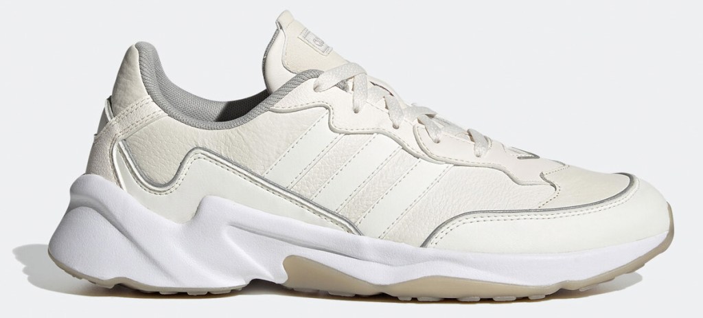 cream colored sneaker with three white adidas stripes on side and white rubber sole