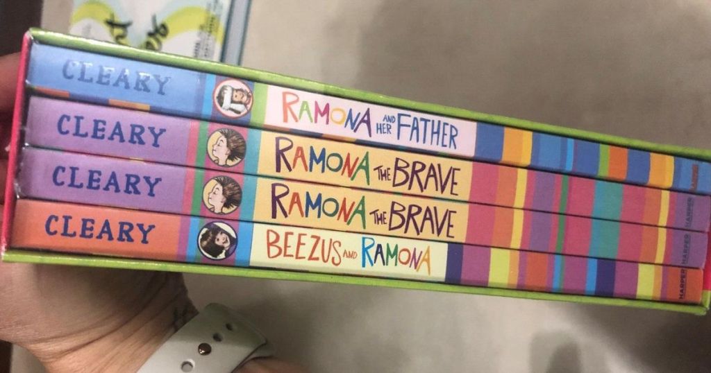 box set of four paperback books held by womans hand