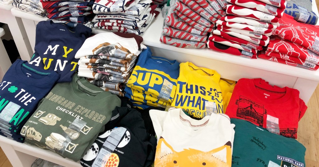 store display table full of folded boys graphic tees