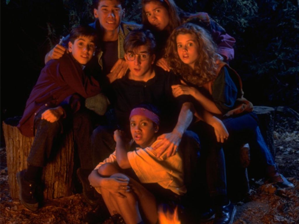 six kids looking scared in front of a campfire