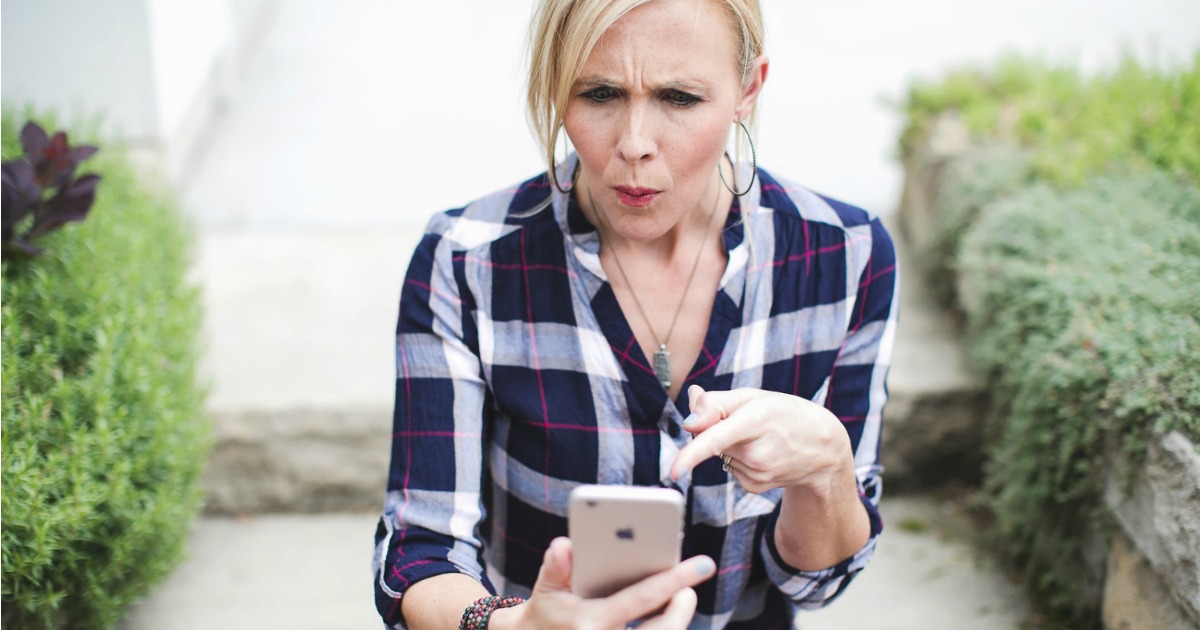 woman looking at iphone pointing to screen