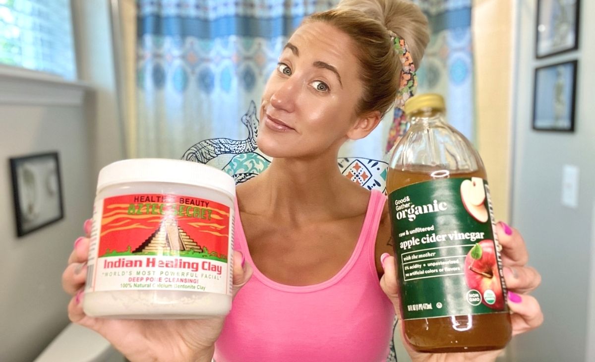 A woman holding armpit detox ingredients in a bathroom