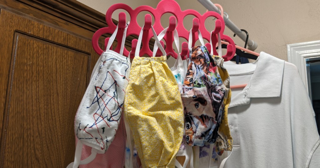 Masks hanging from a pink belt hanger