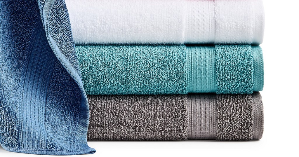 blue, teal, gray, and white bath towels folded in a pile
