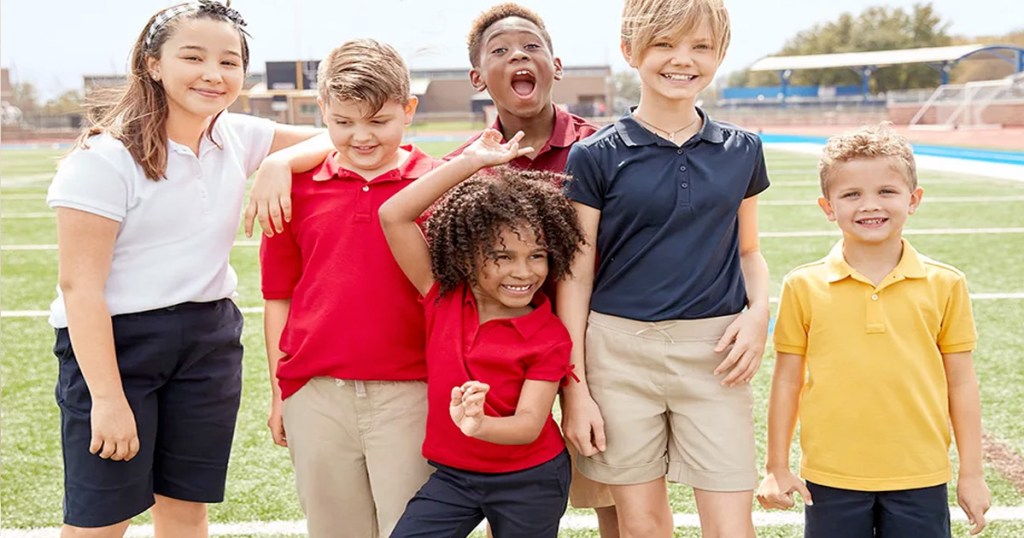 kids wearing school uniform pieces standing on football field