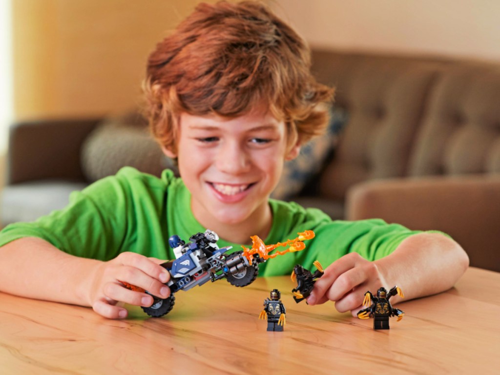 boy playing with a LEGO Marvel Avengers Captain America: Outriders Attack Building Set