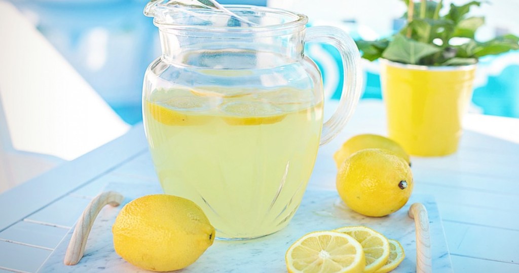pitcher of lemonade on marble serving tray with lemons