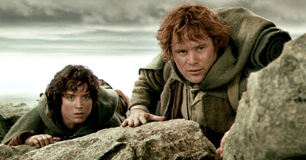 frodo and sam from lord of the rings creeping up to view over a rock