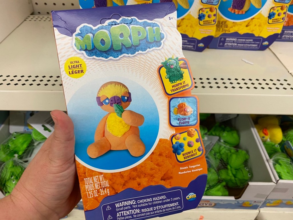 hand holding packaging of orange morph modeling clay
