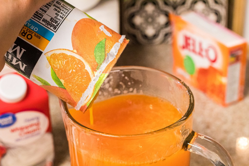 pouring orange juice into pitcher