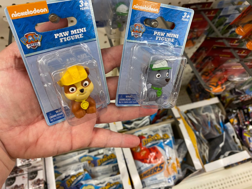 hand holding two paw patrol mini figures