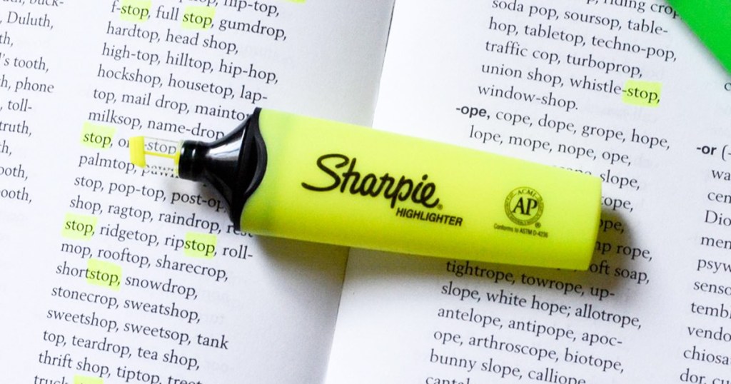 yellow sharpie highlighter laying on book with only the words "stop" highlighted