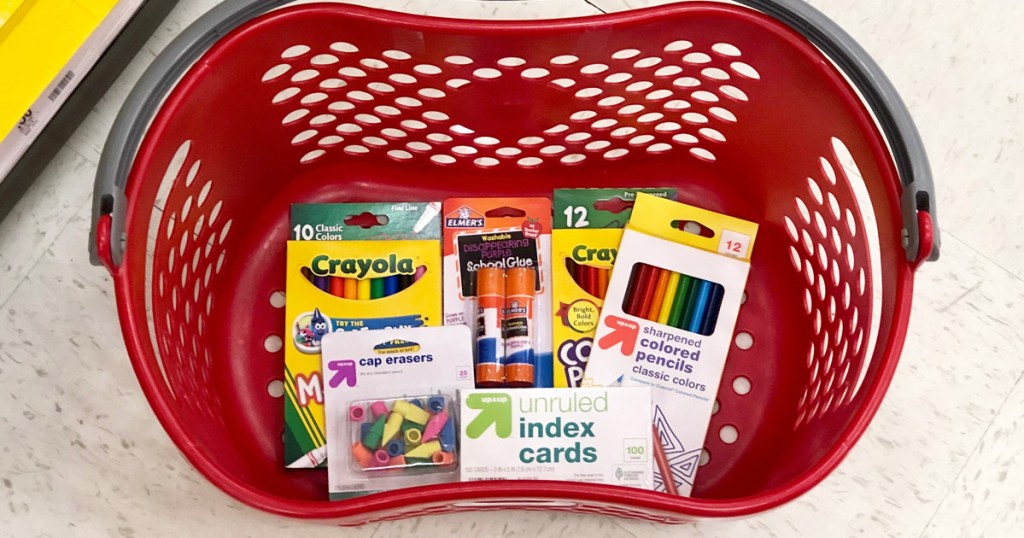 red plastic shopping basket with various school supplies inside