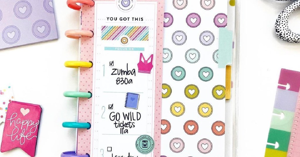 small notebook planner with accessories on white surface