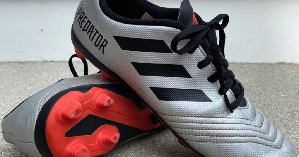 kids silver and black cleats with red bottom