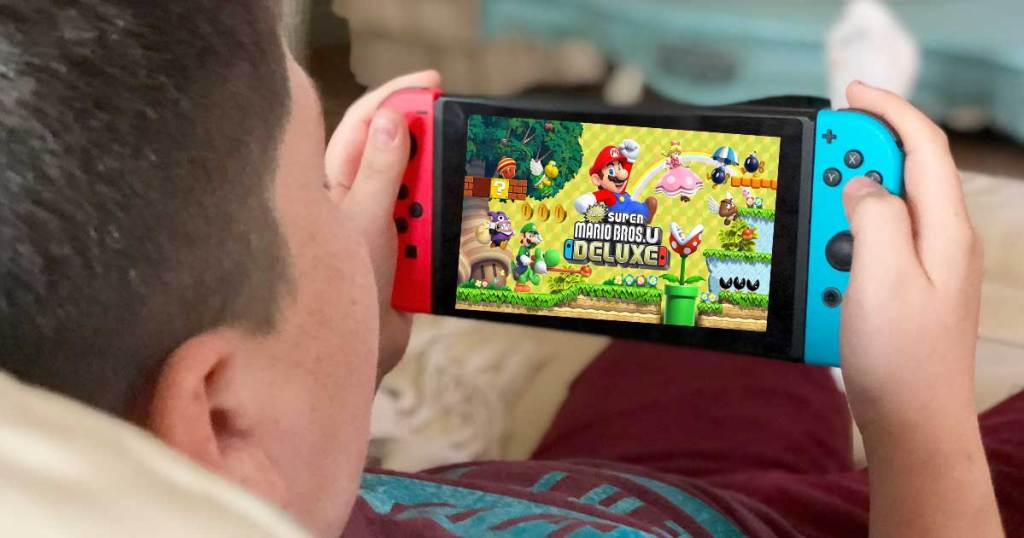 boy holding a nintendo switch and play mario bros