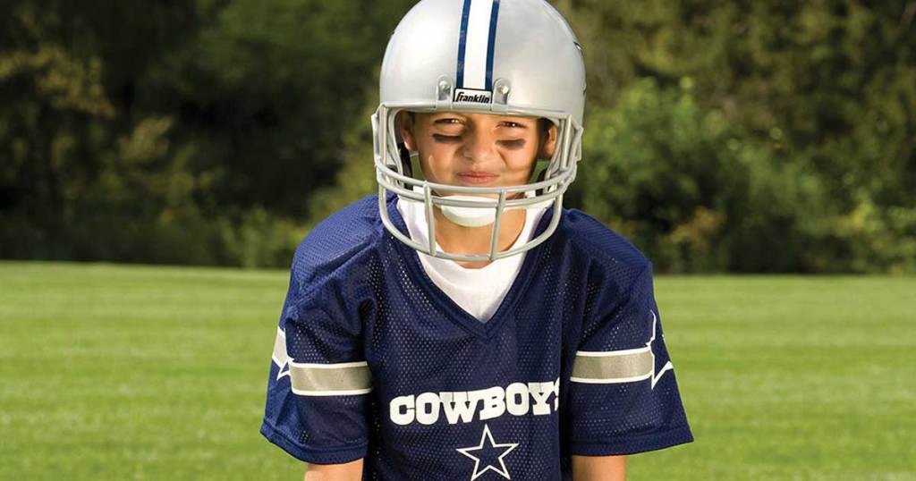 boy in football uniform with helmet