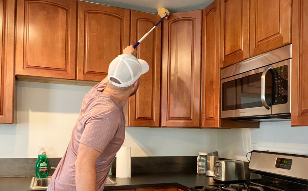 man dusting kitchen