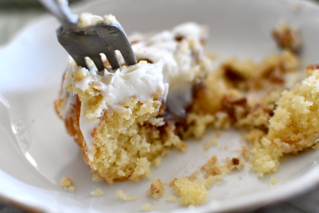 eating cinnamon roll poke cake with fork