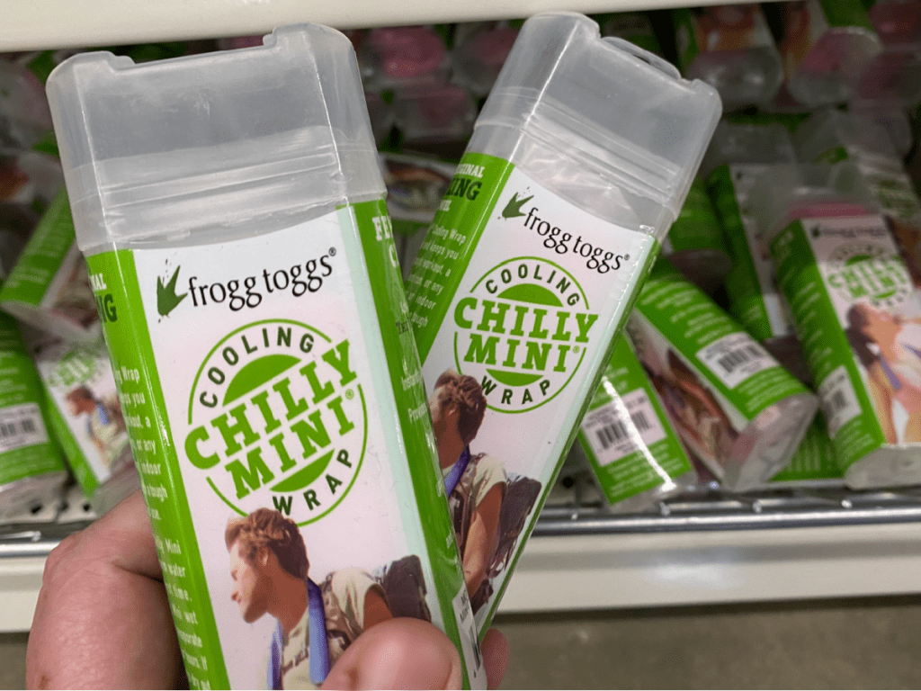 hand holding 2 packages with towels in them in front of store display