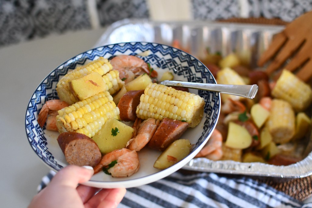 holding a plate of shrimp boil