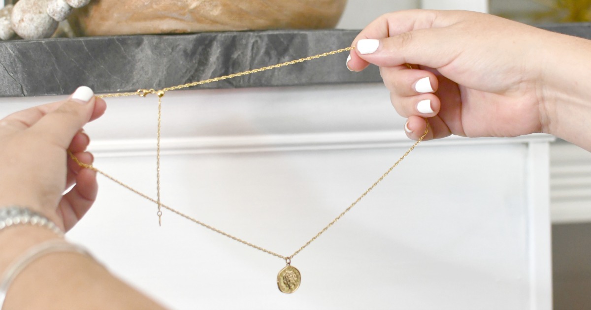 holding an adjustable gold necklace