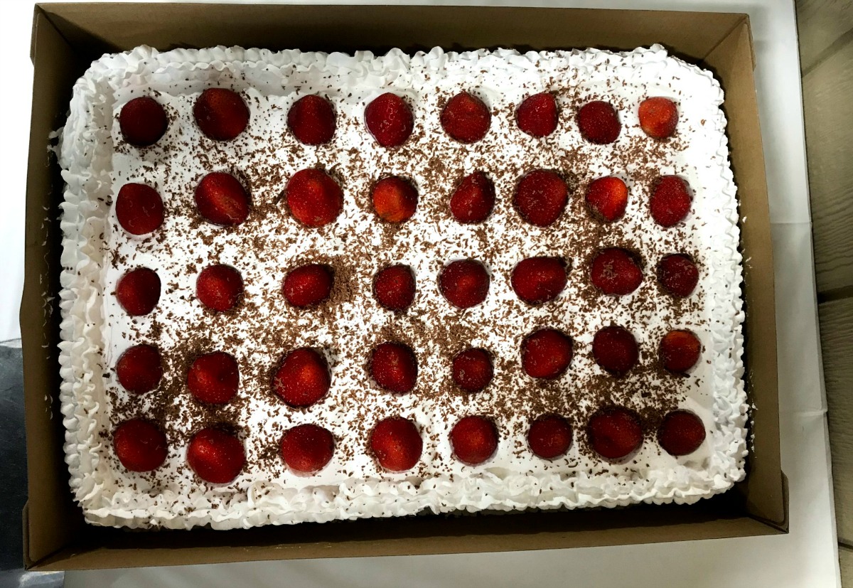 frosted cake decorated with fresh strawberries