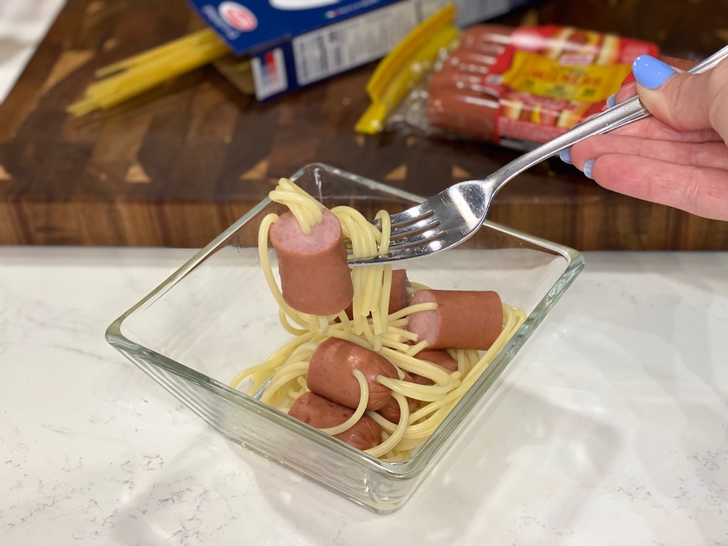 eating hot dog spaghetti with fork