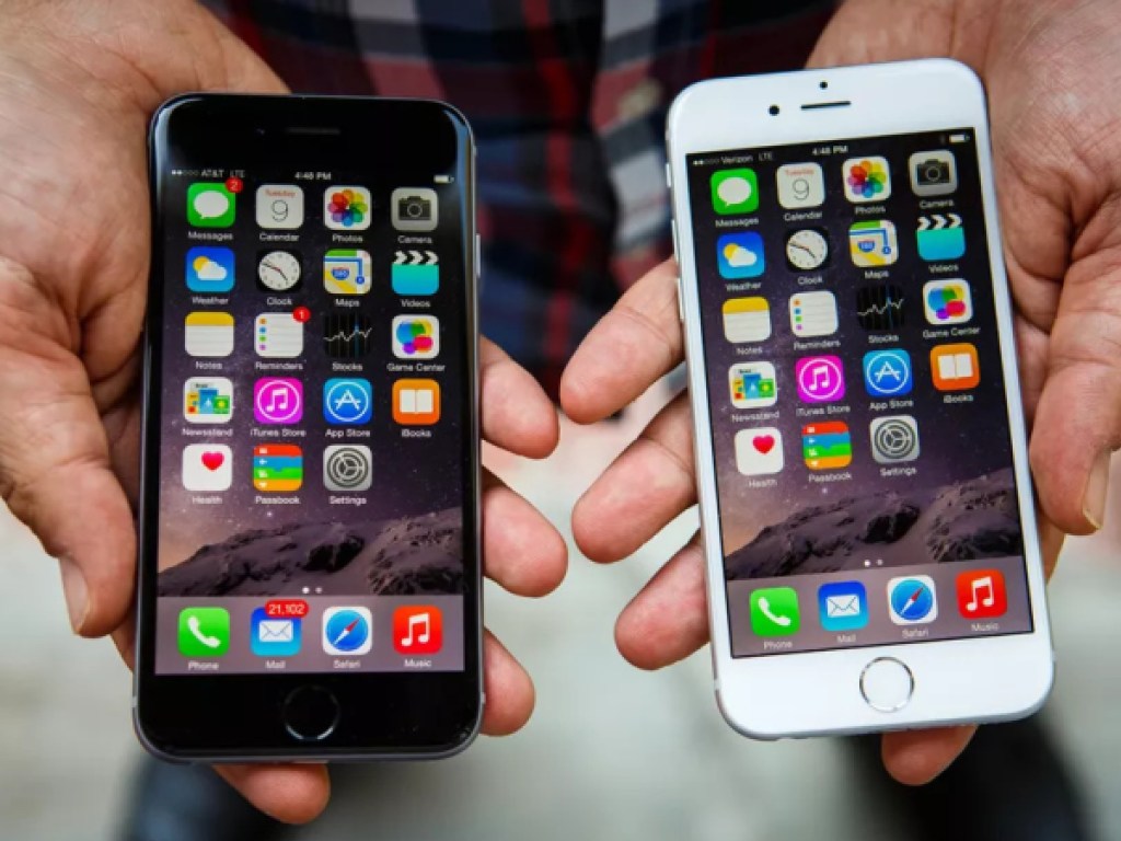 hands holding black iPhone and white iPhone