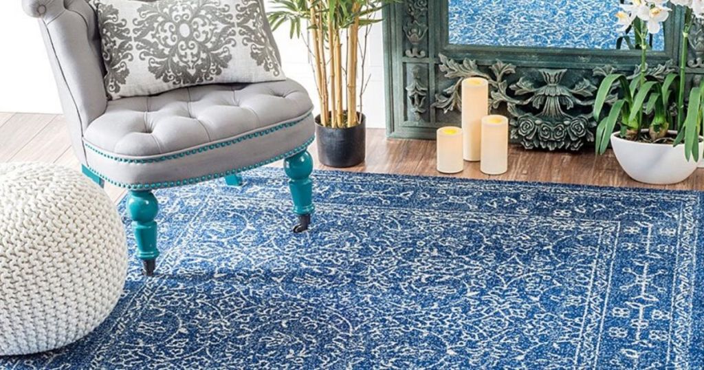area rug with chair, knit poof, potted plant and candles