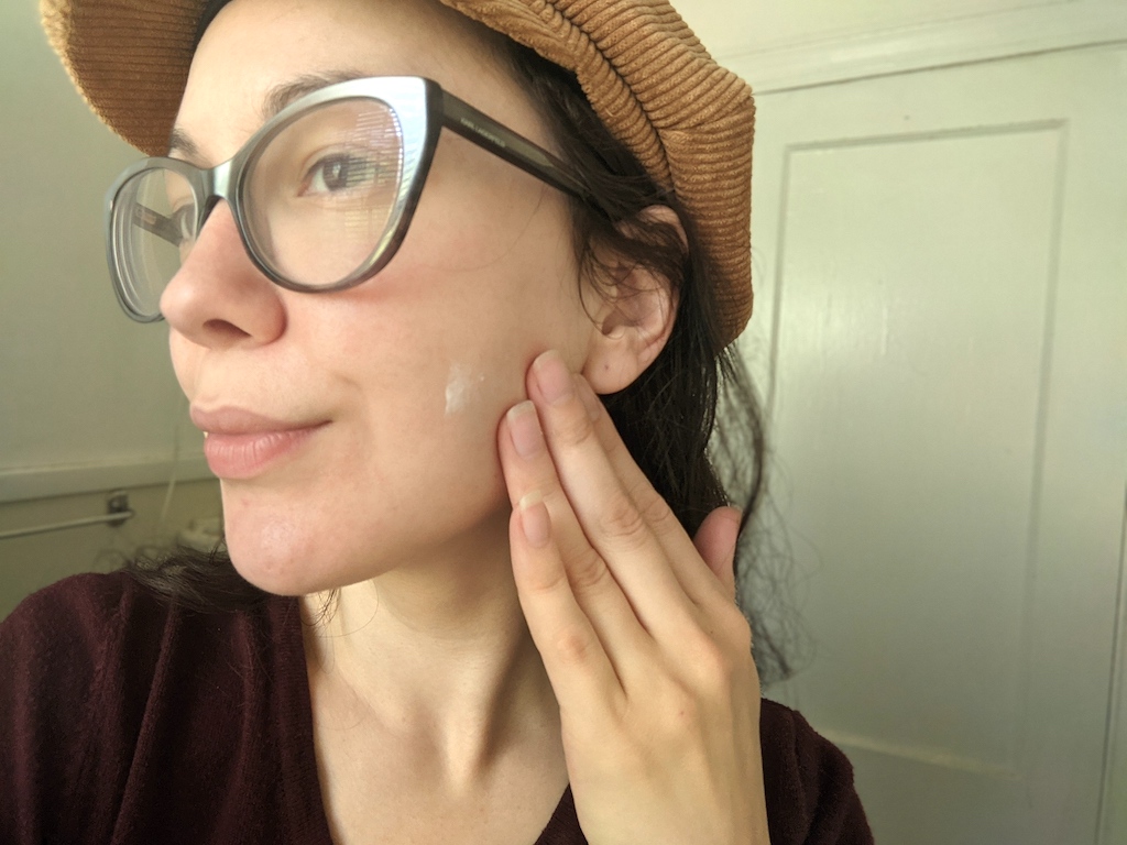 woman putting on acne treatment moisturizer 