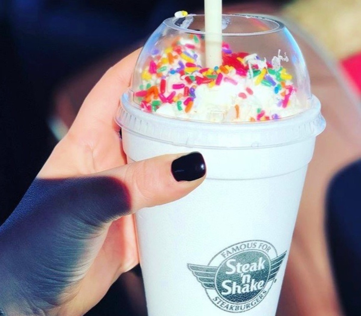 hand holding milkshake in to-go cup