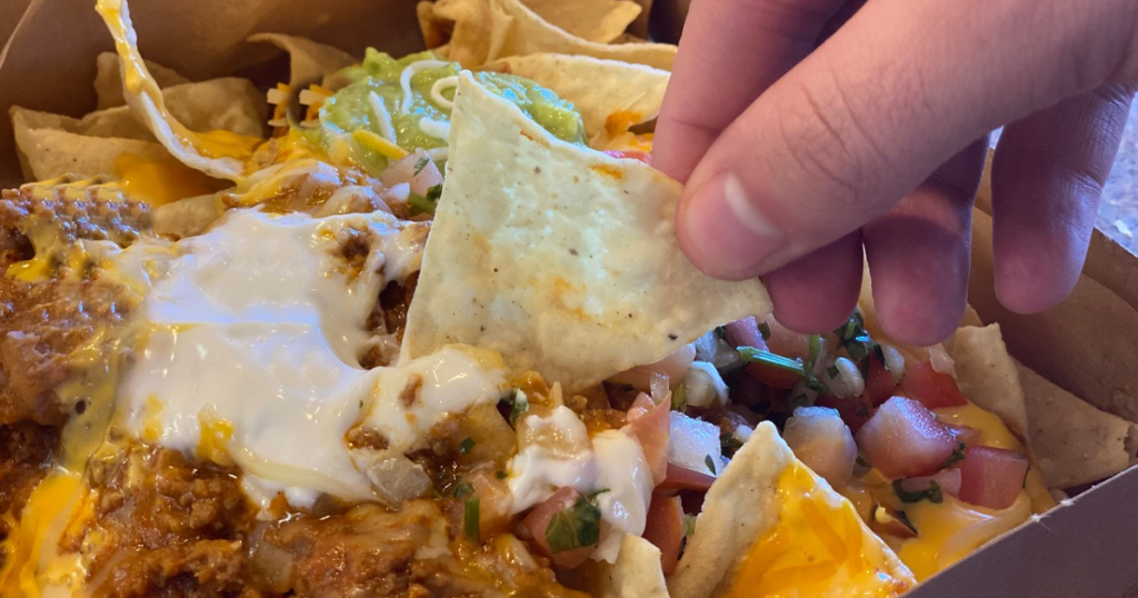 hand reaching into Nachos to eat them