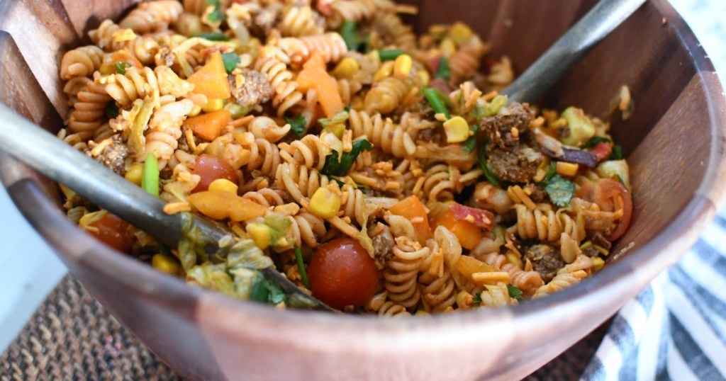 taco pasta salad in wooden bowl with tongs 