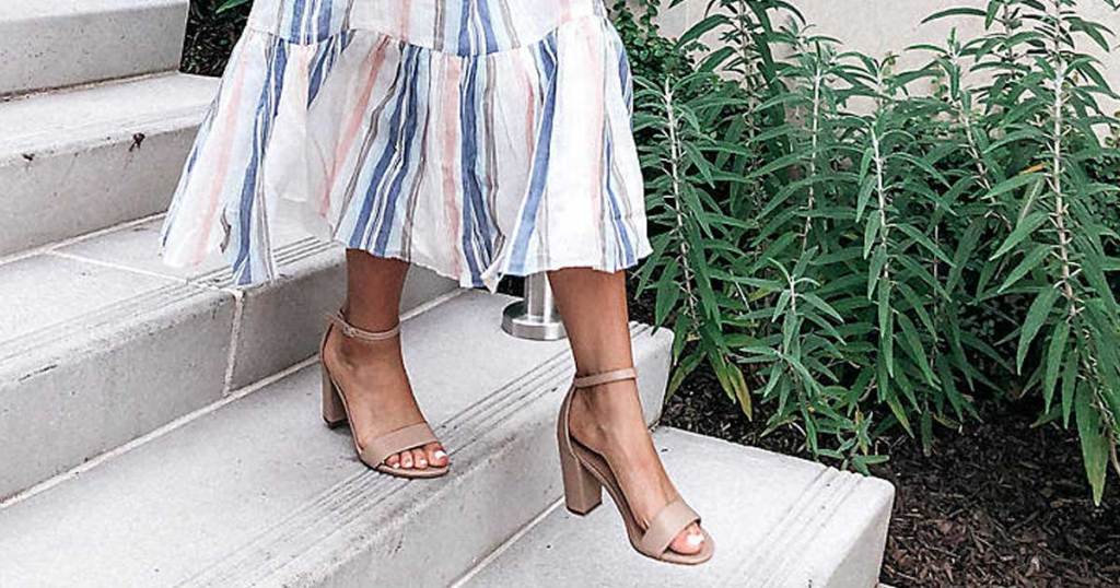 woman wearing sundress and wearing sandals walking down steps