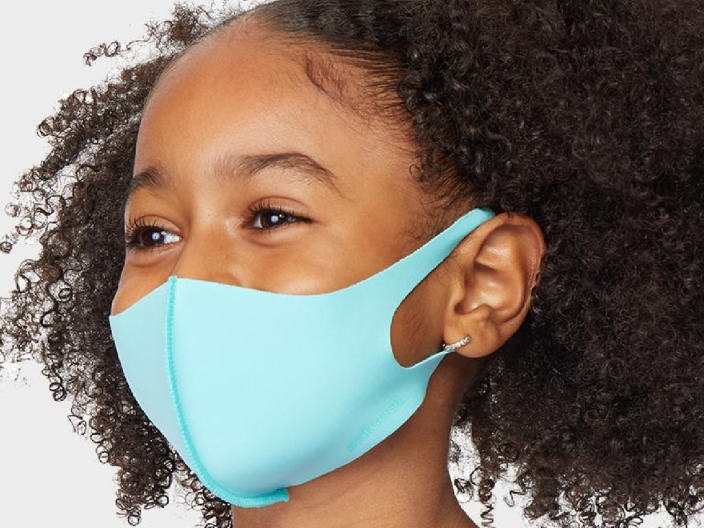little girl wearing a light blue reusable face mask