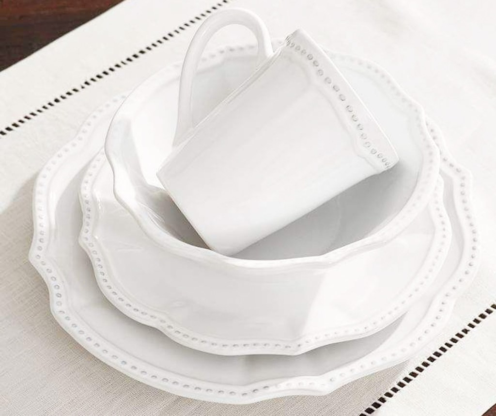 white scalloped edge dinnerware set with dotted print along the edges