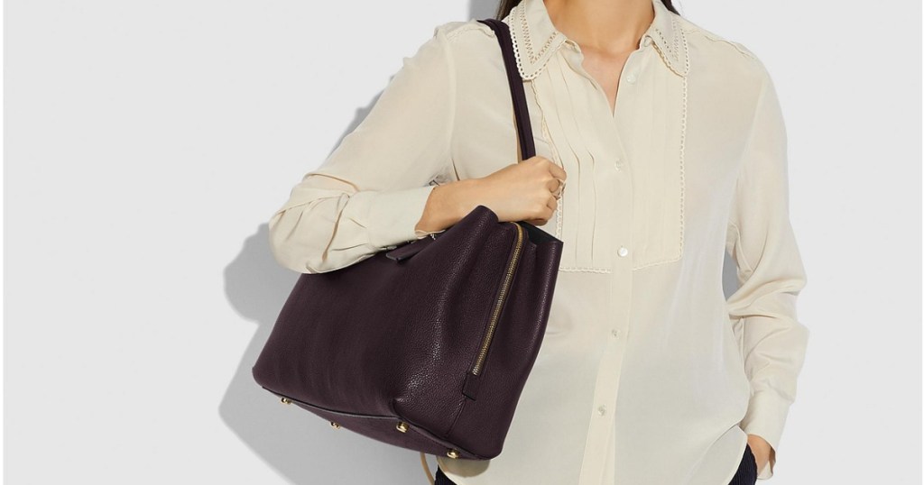 woman wearing white blouse carrying black handbag