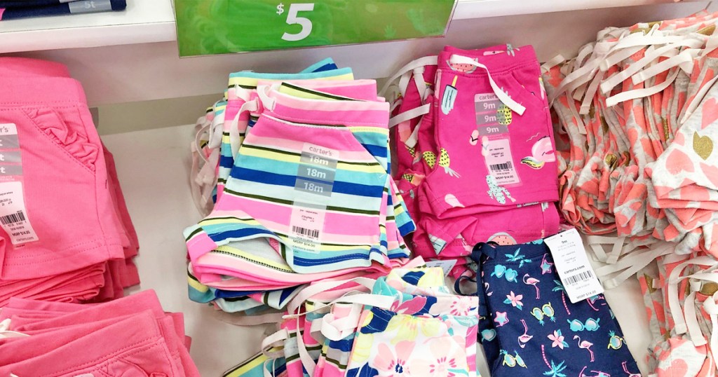 folded Carter's toddler girls shorts on store display table