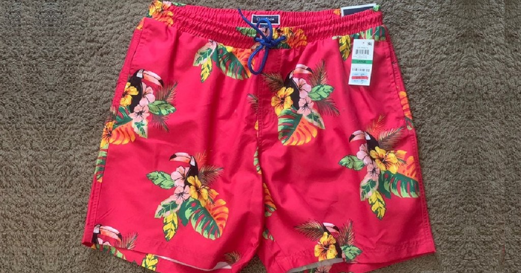 men's pink tropical print swim trunks on carpet