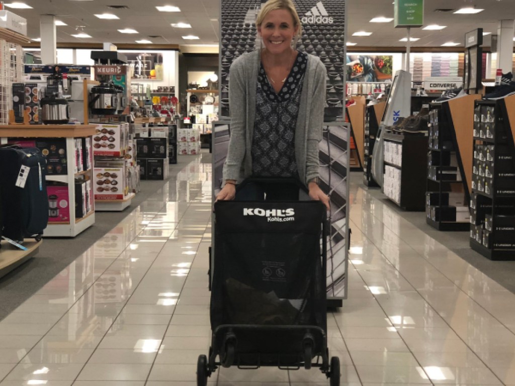 woman leaning on black shopping cart in store