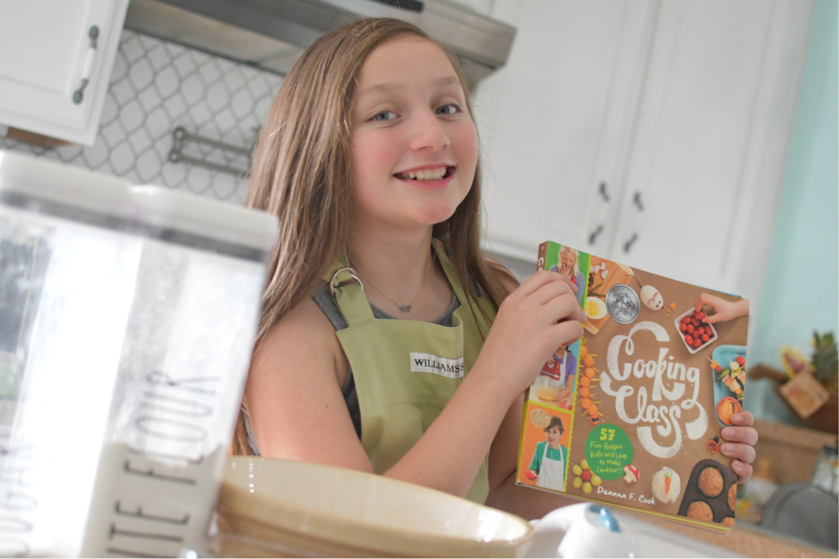 Girl holding Cooking Class Cookbook