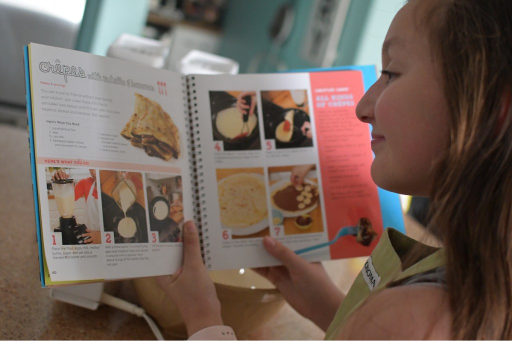 Girl looking over directions for Cooking Class Recipe
