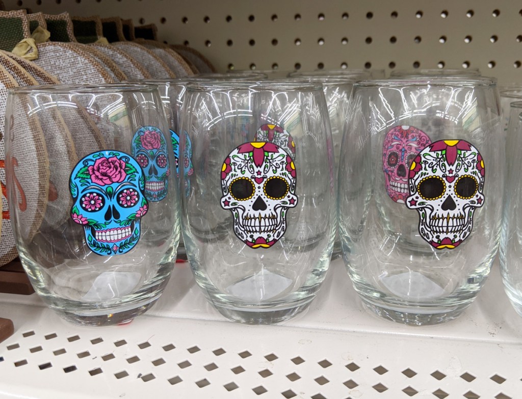 stemless wine glasses with white and blue sugar skulls printed on them on white store shelf