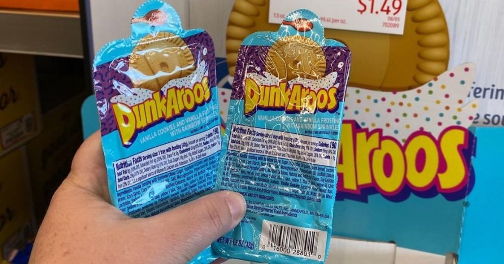 Hand holding two packs of Dunkaroos dippable cookie snacks