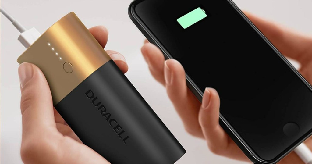 hand holding a phone and a powerbank