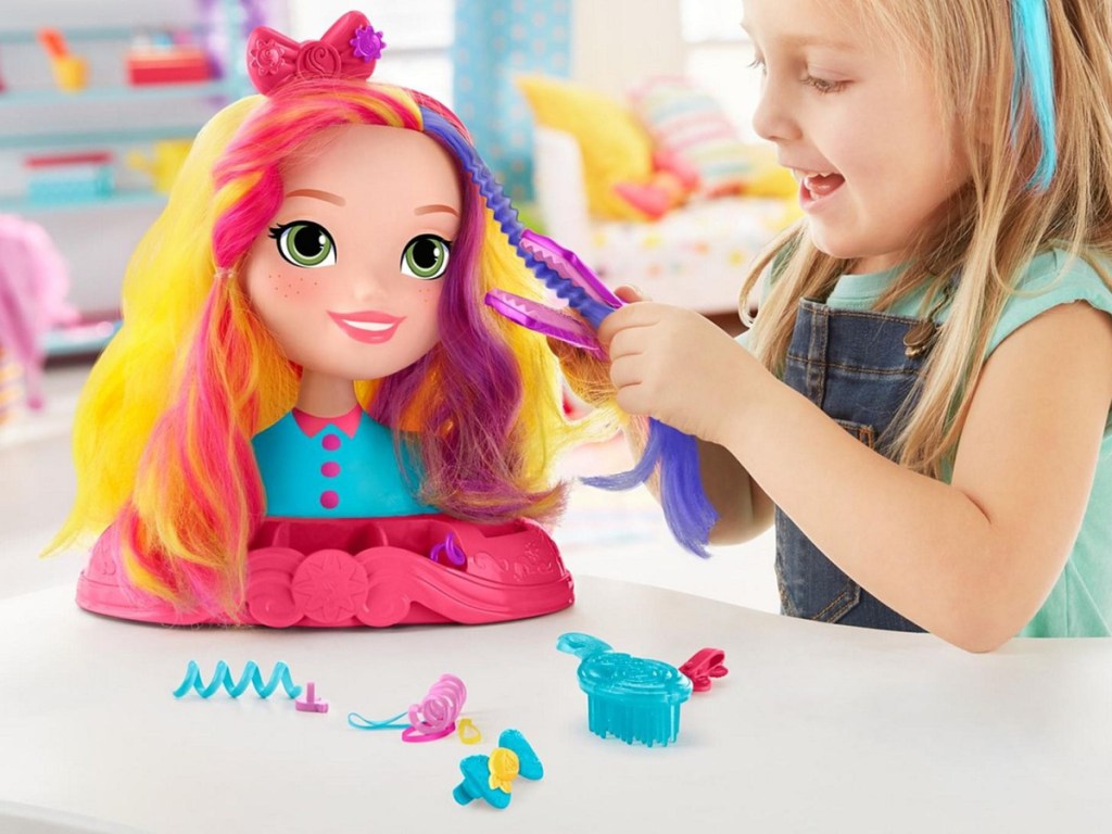 girl playing with doll hair styling head