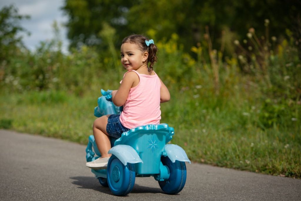 girl looking back while riding Frozen Ride-On Horse